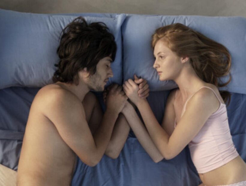 Woman-and-man-lying-face-to-face-in-bed
